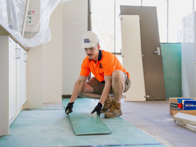 Dash Group labourer installing flooring on a fitout